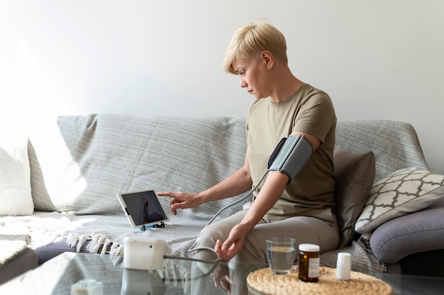 Medium shot woman monitoring blood pressure