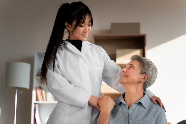 Medium shot woman and nurse holding hands