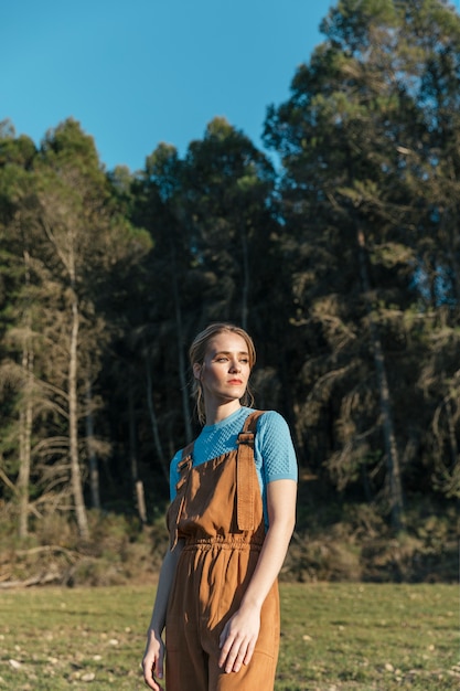 Medium shot woman in overall with trees