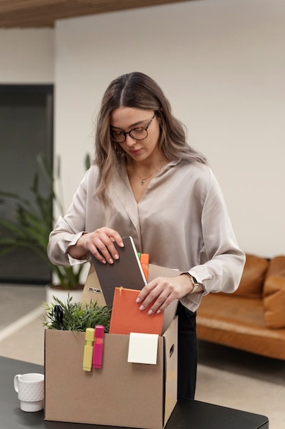 Medium shot woman packing desk items