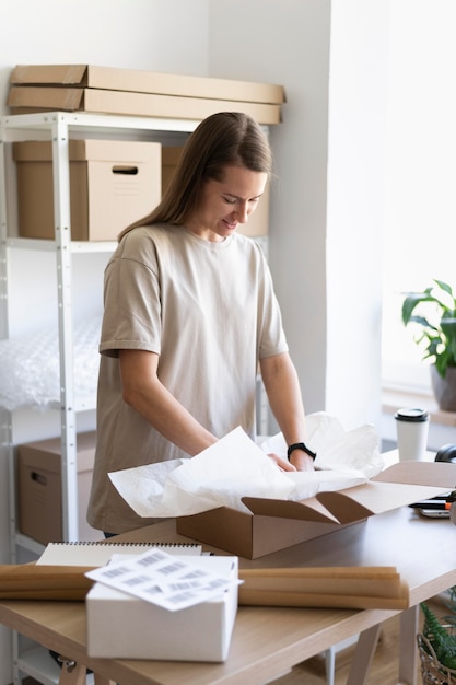 Medium shot woman packing item