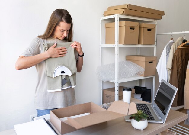 Medium shot woman packing shirt