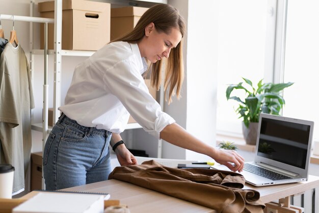 medium shot woman packing shirt