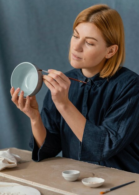 Medium shot woman painting bowl
