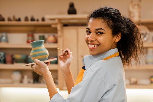 ミディアムショットの女性が土鍋を描く