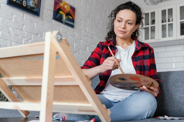 自宅で絵を描くミディアムショットの女性