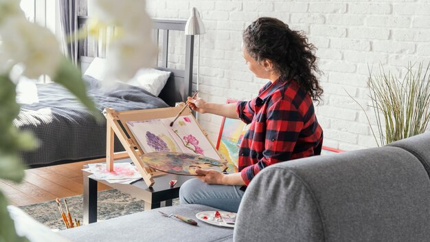 Medium shot woman painting indoors