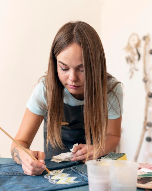 Medium shot woman painting jeans