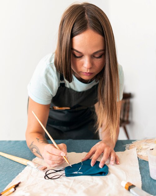 Medium shot woman painting mask