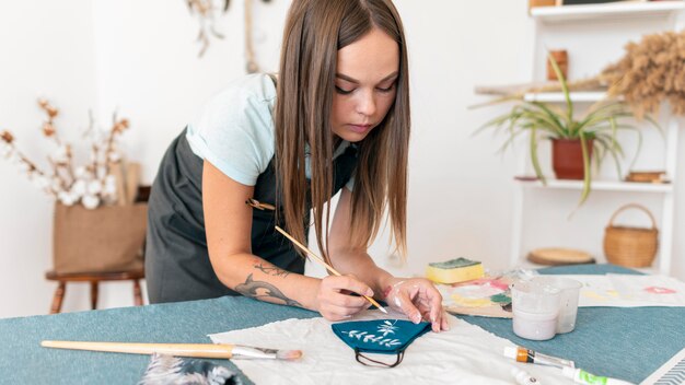 Medium shot woman painting mask