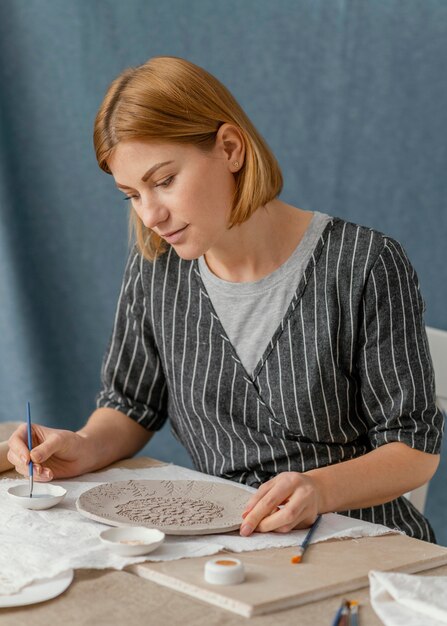 Medium shot woman painting plate