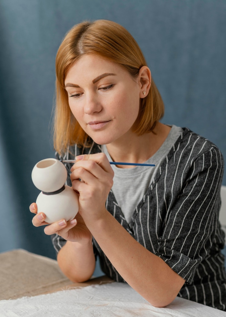 Free Photo medium shot woman painting pottery item