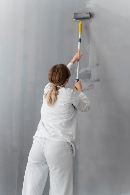 Free photo medium shot woman painting wall