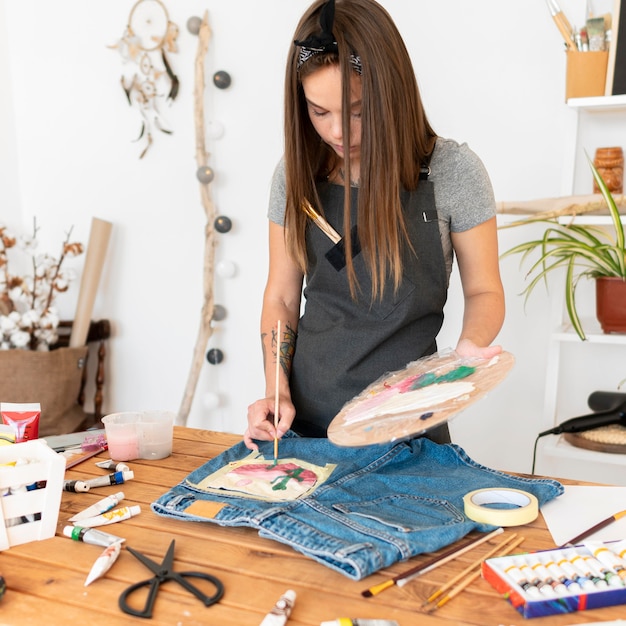 Medium shot woman painting with brush