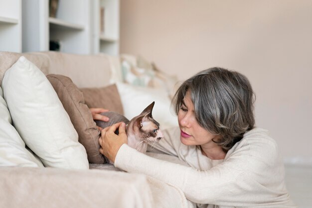 ミディアムショットの女性が猫をかわいがる