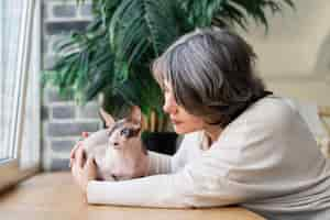 Free photo medium shot woman petting hairless cat