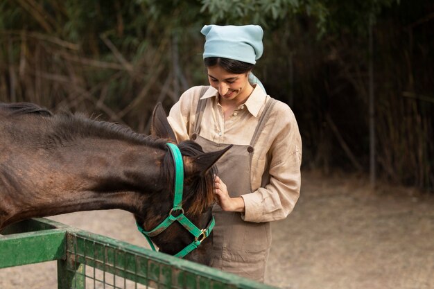 Medium shot woman petting horse