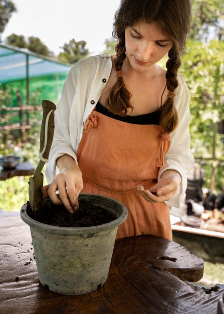 種を植えるミディアムショットの女性