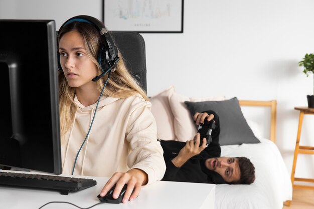 コンピューターでゲームをしているミディアムショットの女性