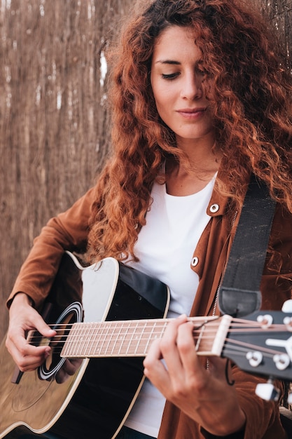 Medium shot woman playing guitar