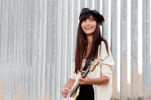 Medium shot woman playing the guitar