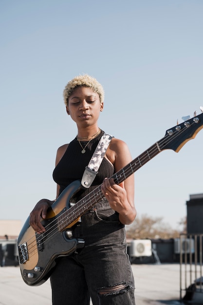 Free photo medium shot woman playing guitar