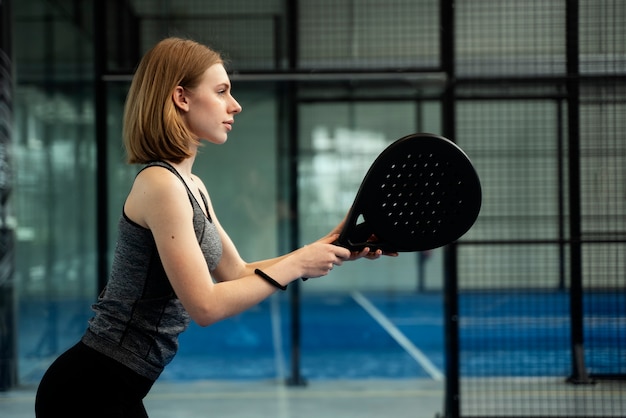 Free photo medium shot woman playing paddle tennis