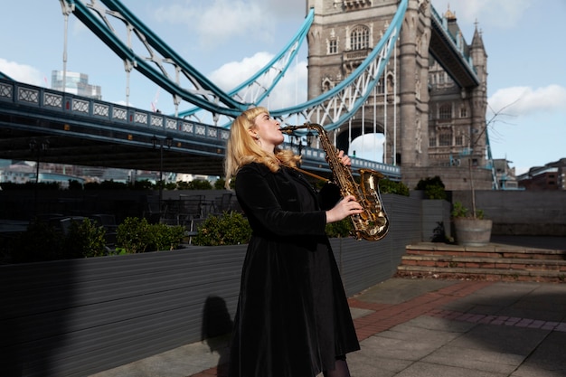 Бесплатное фото Женщина среднего роста играет на саксофоне