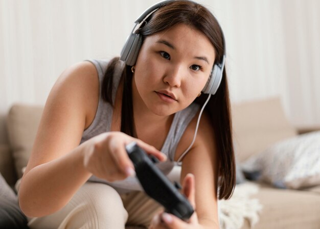 Medium shot woman playing videogame