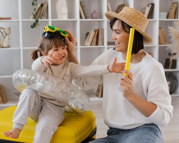 Medium shot woman playing with girl