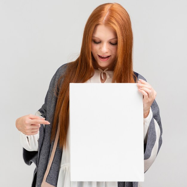 Medium shot woman pointing at canvas