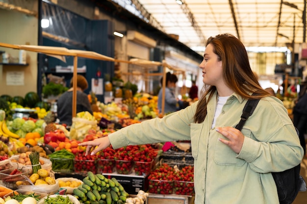 Free photo medium shot woman pointing at vegetable