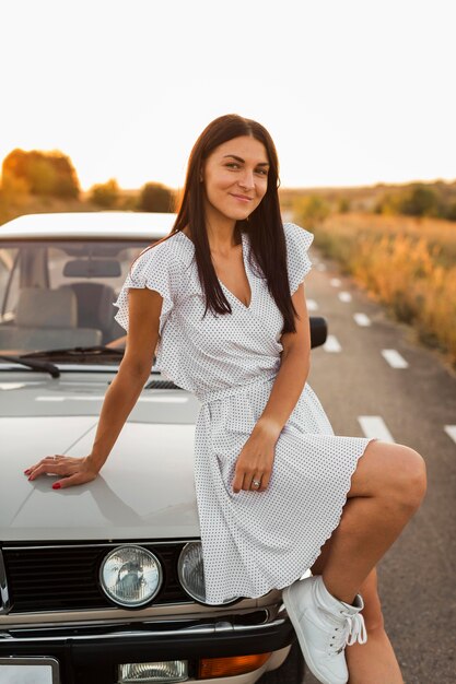 Medium shot woman posing on car