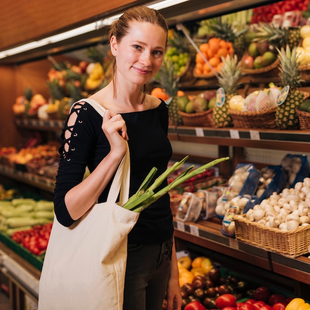 Medium shot woman posing in a grocery store