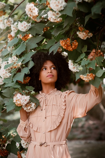 Foto gratuita donna del colpo medio che posa nel giardino romantico