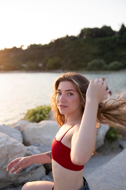 海辺でポーズをとるミディアムショットの女性