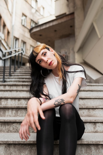 Free photo medium shot woman posing on stairs