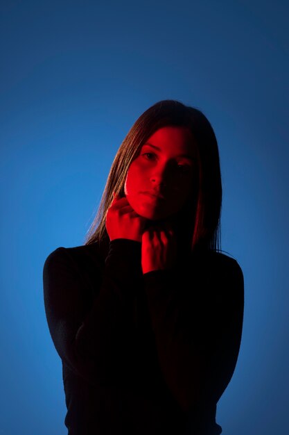 Medium shot woman posing with blue background