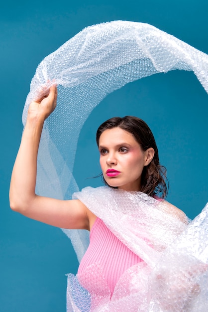 Medium shot woman posing with bubble wrap