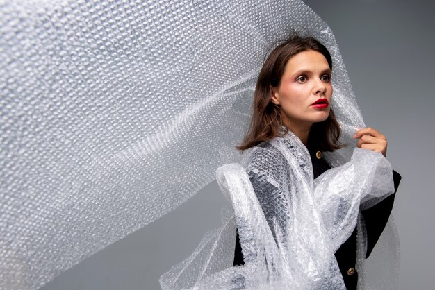 Medium shot woman posing with bubble wrap