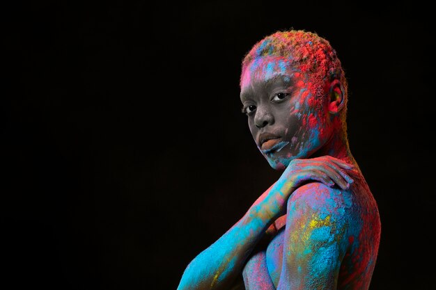 Medium shot woman posing with colorful powder