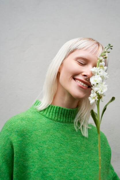 Medium shot woman posing with flower