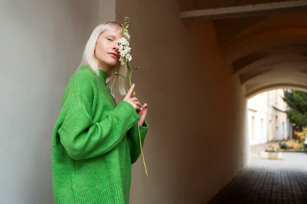 Medium shot woman posing with flower