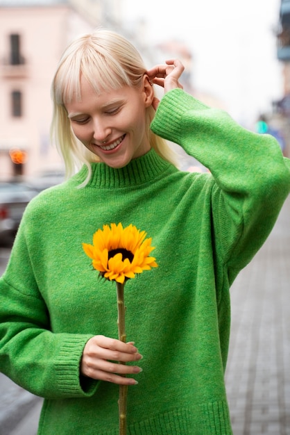 Medium shot woman posing with flower