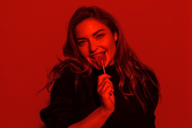 Medium shot woman posing with lollipop