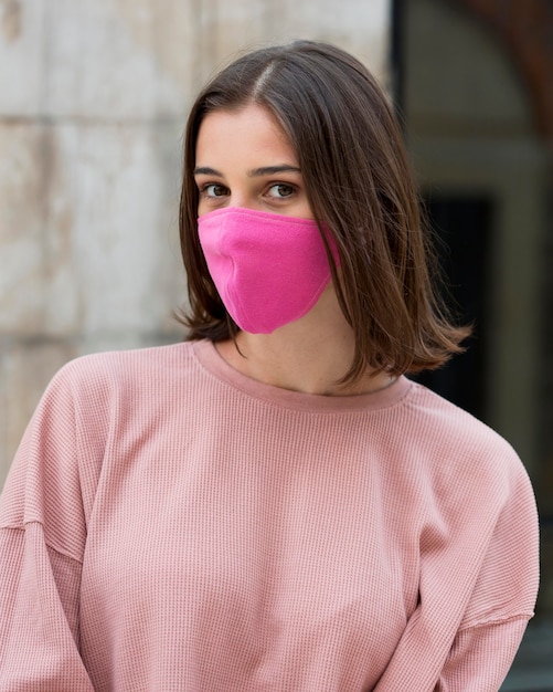 Medium shot woman posing with mask