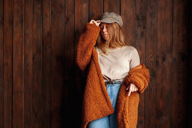 Free photo medium shot woman posing with wooden background