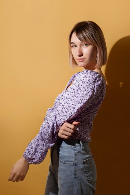 Medium shot woman posing with yellow background