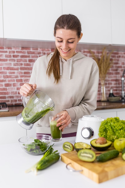 Medium shot woman pouring smoothie