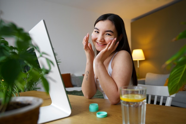 Foto gratuita donna del colpo medio che si esercita nella cura di sé